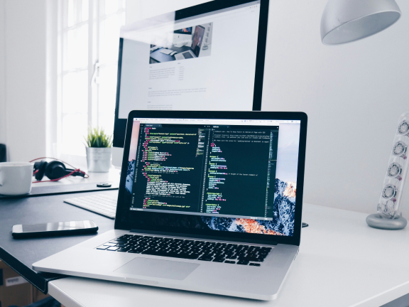 Laptop on a clean desk showing code editor